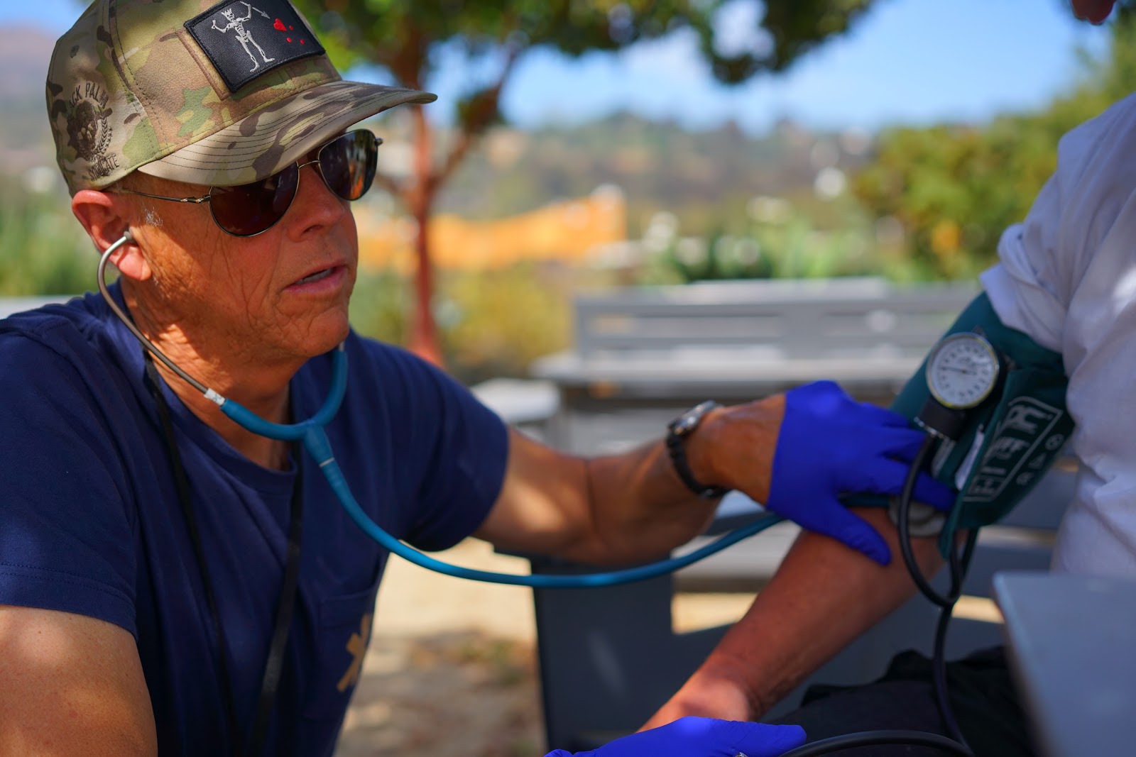 Figure 18.  Peter Miller, street medic, checks vital signs for a patient in the field. Taken by Dr. Coley King of Venice Family Clinic.