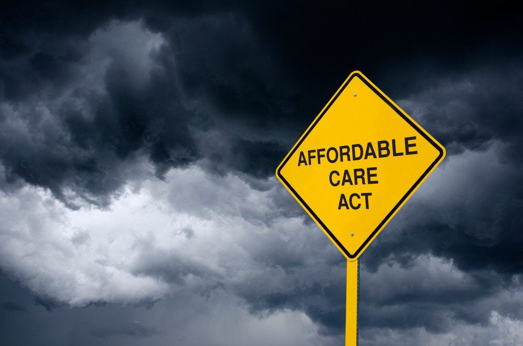 Affordable Care Act Road Sign in Front of Storm Clouds