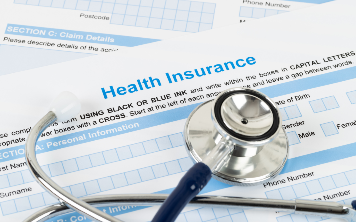 A Stethoscope Rests On Top Of Health Insurance Claim Forms, Highlighting The Connection Between Medical Care And Insurance Paperwork.