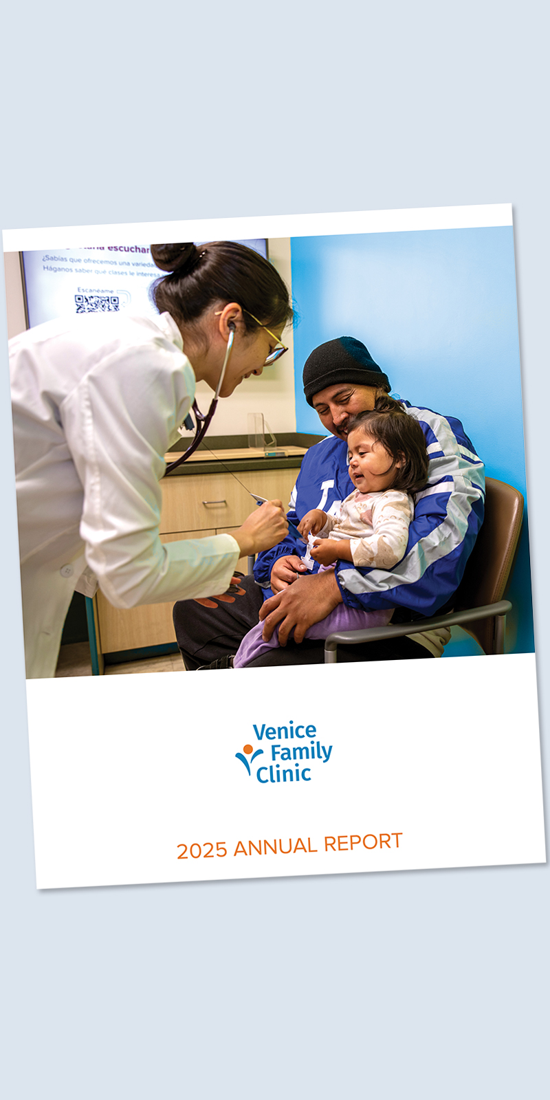 A doctor uses a stethoscope to examine a young girl sitting on a mans lap in a clinic. The cover text reads Venice Family Clinic 2025 Annual Report.