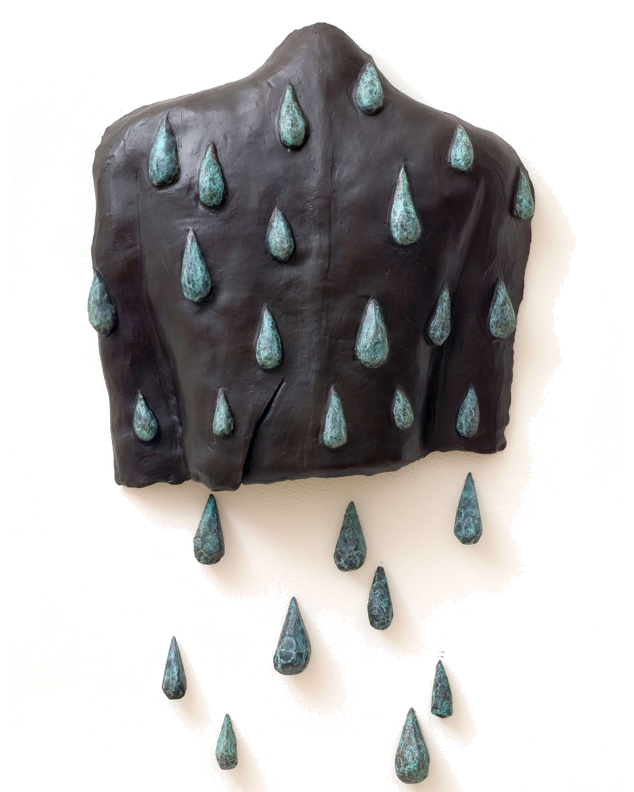 A Dark, Sculpted Torso Hangs On A White Wall With Blue-green Raindrop-shaped Elements Attached, Some Falling Below The Torso, Giving The Impression Of Rain Flowing Off The Figure.